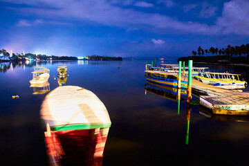 lagoon at night with boats on the water and beautiful reflection of dark sky in pie de la cuesta, lagoon   of coyuca, acapulco guerrero 