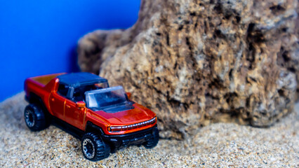 Minahasa, Indonesia : Monday, 12 December 2022, toy car on the sand on a blue background © 42L