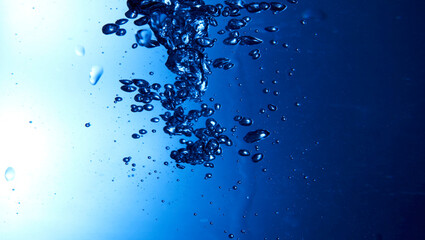 Drops of water falling into deep blue water
