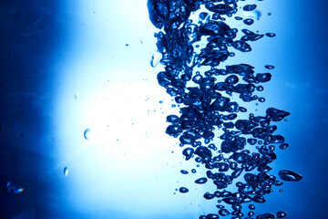 Drops of water falling into deep blue water