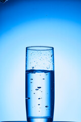 closeup of pouring water on the cup on transparent blue background