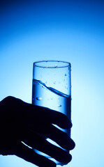 closeup of pouring water on the cup on transparent blue background