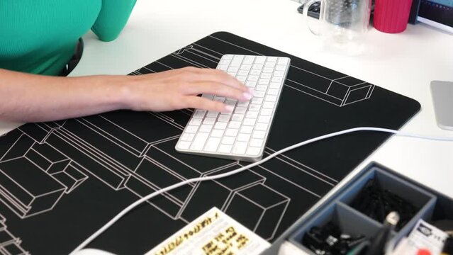 Sexy Blonde Girl in office wearing green does mous scrolling typing on white keyboard on with desk