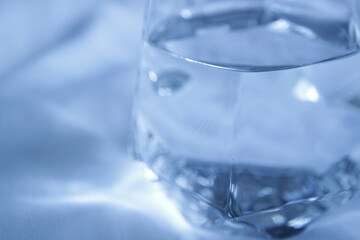 透明なグラスに入った水　白背景　余白スペース　シンプル　透き通った水　綺麗