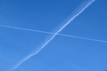 The intersection of jet contrails in the blue sky