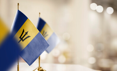 Small flags of the Barbados on an abstract blurry background