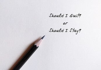 Pencil write on paper SHOULD I QUIT or SHOULD I STAY, concept of decision making to leave job, to...