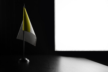 Small national flag of the Vatican on a black background