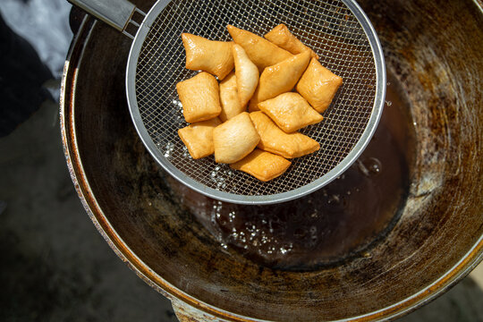 Traditional Kazakh and central asian fresh baursaks are taken out of a large cauldron. Traditional appetizer for Nauryz holiday.