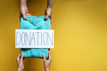 Donation Concept. The volunteer giving a donate clothes to the recipient.