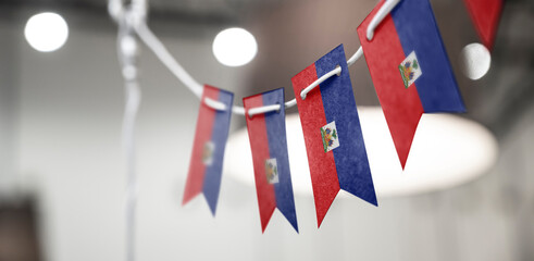 A garland of Haiti national flags on an abstract blurred background