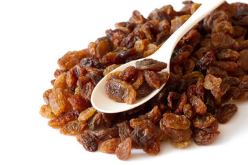 Lots of raisins on a white background. Raisins in a spoon. A bunch of delicious beautiful raisins.