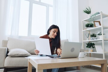 Smile woman working from home on laptop, freelance work online with documents