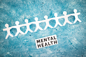 Menatal health text next to paper people chain,  psychology and need for help