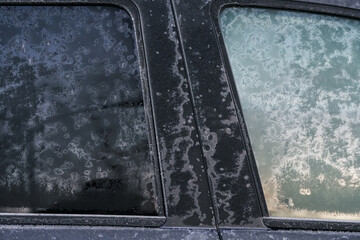 Freezing winter temperatures. Close up view with a frozen car parked outside during a freezing morning.