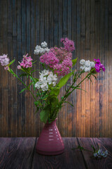 Still life with flowers in a vase on a dark background