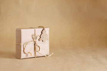 Zero waste Christmas. Handmade brown paper gift box with Cristmas ornament made of sackcloth. Backdrop with copy space