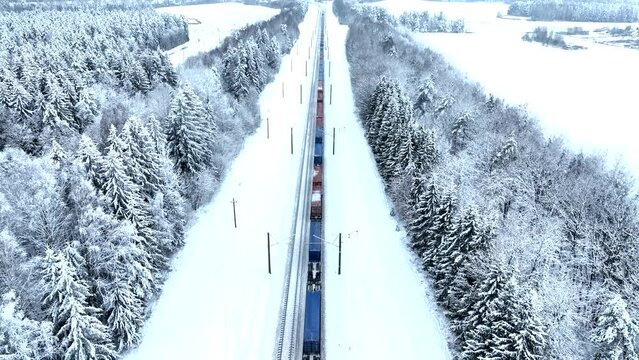 Shipping containers transportation on freight train by railway. Cargo Containers On Railroad in winter snow. Intermodal sea Container On Train Car in winter season. Rail Freight Shipping Logistics.