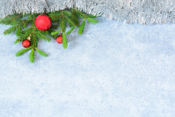 Gray background with fir branches, red christmas balls and garland with copy space