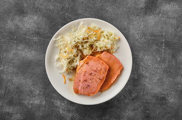 Backed Kasseler pork steak with sauerkraut. Smoked pork lion. Sliced smoked pork chop on wooden board
