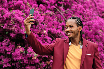 Cool african man taking a selfie in a garden