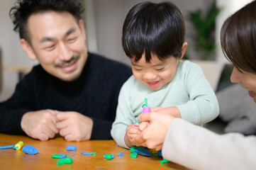 粘土で遊ぶ幼児と家族