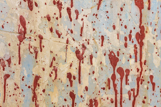 Dirty and peeling old wall background with splashes of red paint in abstract composition