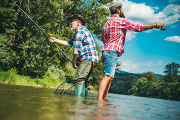 Fisherman men friends and trophy trout. Father and son fishing. Generations men fishing in river.