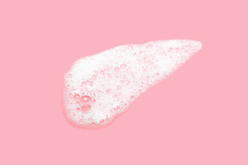 Fototapeta premium Smear of facial cleansing foam on pink background close-up.