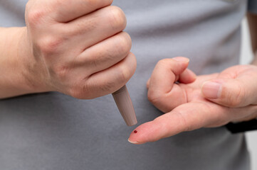 Man measures his blood sugar. Glaucometer, blood sample test, diabetes concept.