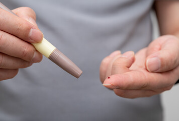 Man measures his blood sugar. Glaucometer, blood sample test, diabetes concept.
