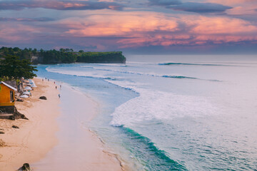 Holiday beach with sunset sky and ocean waves in Bali