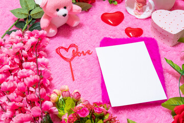 White blank notebook paper above a notebook surrounded by valentine themed decorations