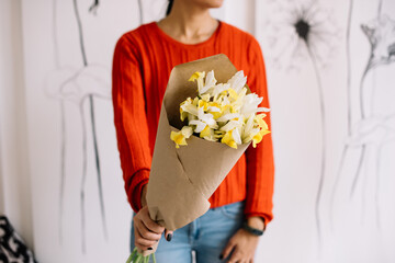 Very nice young woman holding beautiful mono bouquet of fresh iris flowers in yellow colors, cropped photo, bouquet close up - 555058754