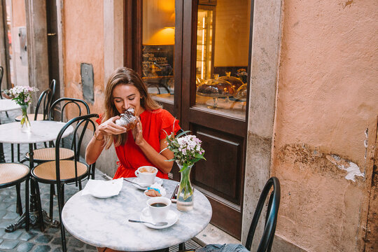 Woman Eating Croissant in Rome Italy
