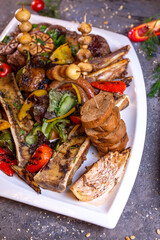 A set of different beef meat dishes on a white plate