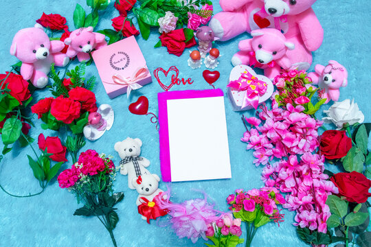 White blank notebook paper above a notebook surrounded by valentine themed decorations