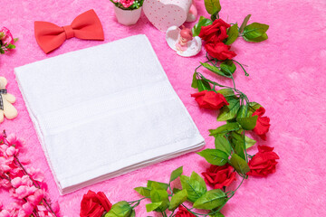 White blank towel above a fluffy pink carpet surrounded by valentine themed decorations