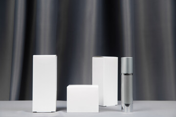 white and gray packaging for cosmetics on a gray background