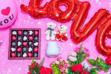 White blank milk mug on the top of a fluffy pink carpet surrounded by valentine themed decorations