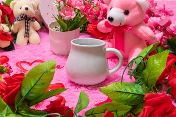 White milk mug on the top of a fluffy pink carpet surrounded by valentine themed decorations