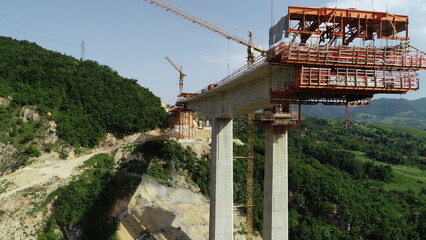 Aerial drone view on highway bridge road under construction. Construction of the viaduct on the...