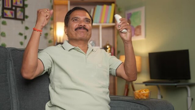 Middle Aged Man Celebrating Goal By Shouting While Watching Football Live Match On Tv Or Television At Home - Concept Of Entertainment, Carefree And World Cup Tournament.