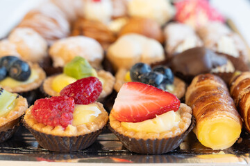 Assortment of delicious and colorful pastries close up, made by pastry chef. All look tasty and delightful. Perfect for a  party. Natural light