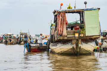 Fototapeta na wymiar Merchants trading goods between rustic wooden boats on a river at Chau Doc in Vietnam