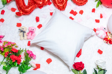 White blank pillow above a a fluffy white carpet surrounded by valentine themed decorations