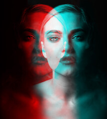 Studio portrait of beautiful woman blowing smoke from mouth in RGB color split. RGB effect make...