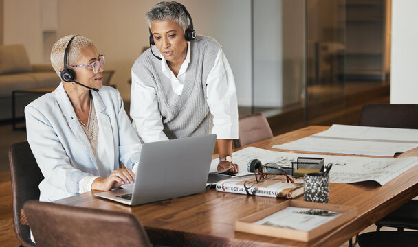 Customer support, call center and manager helping consultant with an online consultation in the office. Customer service, telemarketing and senior leader consulting agent on laptop in the workplace.