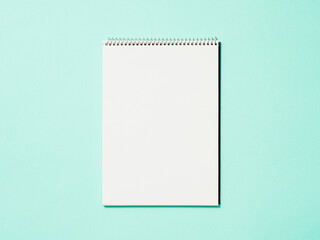 Paper notebook. Empty paper sketchbook on blue background. Top view or flat lay. Copy space for text or design.