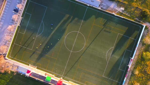Spinning downwards drone shot of a football field during golden hour in Santa Ponsa, Mallorca, Spain.